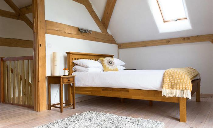 main bedroom upstairs with lounge area and balcony